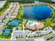This aerial shows a community with a lake, tennis courts, a pool, and manicured landscaping at 11700 Tapestry Ln, Venice, FL 34293