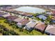 Beautiful aerial view of homes surrounding a peaceful lake with fountains and community tennis courts at 11700 Tapestry Ln, Venice, FL 34293