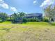 Expansive backyard with lush landscaping and palm trees surrounding screened-in enclosure at 11700 Tapestry Ln, Venice, FL 34293