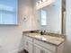 Bright bathroom features granite counters, white cabinets and trim, and a window over the sink at 11700 Tapestry Ln, Venice, FL 34293