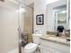 Well-lit bathroom with granite counters, tiled shower, and modern fixtures at 11700 Tapestry Ln, Venice, FL 34293
