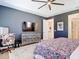 Bedroom with dark gray accent wall, ceiling fan, and walk-in bathroom at 11700 Tapestry Ln, Venice, FL 34293