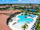 This aerial view features a resort-style pool with lounge chairs and palm trees in a Gathering-friendly community at 11700 Tapestry Ln, Venice, FL 34293