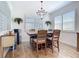 Charming dining room features modern chandelier lighting, plantation shutters, and wood-style tile flooring at 11700 Tapestry Ln, Venice, FL 34293