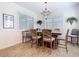 Elegant dining room with a chandelier, neutral paint, plantation shutters, and wood-look tile flooring at 11700 Tapestry Ln, Venice, FL 34293