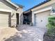 Wide view showing a two-car garage and stone-accented entrance, and brick pavers at 11700 Tapestry Ln, Venice, FL 34293