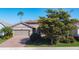 Charming single-story home with a two-car garage, stone accents and manicured lawn at 11700 Tapestry Ln, Venice, FL 34293