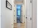 Hallway with wood flooring leading to a well-lit bedroom at 11700 Tapestry Ln, Venice, FL 34293