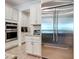 Modern kitchen featuring stainless steel appliances, white cabinetry, and wood-look tile flooring at 11700 Tapestry Ln, Venice, FL 34293