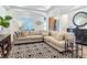 Stylish living room with a comfortable sectional sofa, patterned rug, modern decor, and ample natural light at 11700 Tapestry Ln, Venice, FL 34293