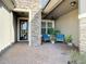 Inviting patio with stone accents, comfortable seating, ceiling fan, and landscaped surroundings at 11700 Tapestry Ln, Venice, FL 34293