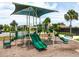 A colorful community playground with slides and climbing equipment, shaded by a large canopy at 11700 Tapestry Ln, Venice, FL 34293
