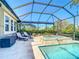 Screened-in pool features a spa, lounge chairs, tropical landscaping, and a tranquil outdoor oasis at 11700 Tapestry Ln, Venice, FL 34293