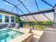 Inviting screened-in pool and spa with stone accents and lounge chairs at 11700 Tapestry Ln, Venice, FL 34293