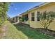 Exterior view showcasing the home's backyard landscaping and sunroom at 121 Auburn Woods Cir, Venice, FL 34292