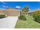 Charming home with well-manicured lawn, lush landscaping, and an attached two-car garage at 121 Auburn Woods Cir, Venice, FL 34292