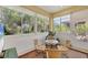 Bright sunroom with floor-to-ceiling windows offering serene views of lush greenery at 121 Auburn Woods Cir, Venice, FL 34292