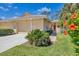 Charming villa featuring lush landscaping, a tile roof, and a welcoming entryway with a covered porch at 121 Auburn Woods Cir, Venice, FL 34292