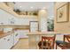 Bright kitchen featuring white cabinets, a breakfast bar with seating, and views into the living space at 121 Auburn Woods Cir, Venice, FL 34292