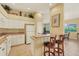 Well-lit kitchen features white cabinets, a breakfast bar with seating, and views into the living space at 121 Auburn Woods Cir, Venice, FL 34292