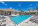 Community pool featuring clear blue water, lounge chairs, and a view of the clubhouse at 121 Auburn Woods Cir, Venice, FL 34292