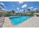Community pool area with clear blue water surrounded by lounge chairs and lush landscaping on a sunny day at 121 Auburn Woods Cir, Venice, FL 34292