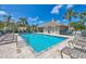 Community pool with clear blue water, lounge chairs, and a clubhouse at 121 Auburn Woods Cir, Venice, FL 34292