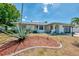 Charming home with lush, tropical landscaping and shutters under a beautiful sunny sky at 1281 Wilson Dr, Englewood, FL 34224
