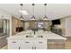 Bright kitchen island with seating, modern fixtures, stainless appliances, and open concept living area at 1281 Wilson Dr, Englewood, FL 34224