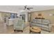 Bright, open-concept living room features modern furniture, a ceiling fan, and an eat-in kitchen with a large island at 1281 Wilson Dr, Englewood, FL 34224