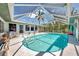Enclosed pool featuring a clear blue pool, covered area, and comfortable lounge seating for relaxation at 1281 Wilson Dr, Englewood, FL 34224