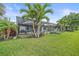 Inviting backyard with lush landscaping, screened-in lanai, and a tranquil outdoor living space at 13215 Amerigo Ln, Venice, FL 34293