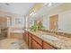 Bathroom featuring double sinks, granite countertops, and a tiled shower and soaking tub at 13215 Amerigo Ln, Venice, FL 34293