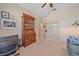 Charming bedroom featuring neutral walls, a ceiling fan, a wooden hutch, and a cozy seating area at 13215 Amerigo Ln, Venice, FL 34293