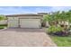 Beautiful home exterior featuring a stone facade, well-manicured landscaping, and a paver driveway at 13215 Amerigo Ln, Venice, FL 34293