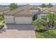 Beautiful tile roof tops this home, while the three car garage sits along the red brick driveway at 13215 Amerigo Ln, Venice, FL 34293