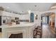 Eat in kitchen with a breakfast bar, white cabinets, stainless steel appliances, tile backsplash, and hardwood floors at 13215 Amerigo Ln, Venice, FL 34293