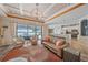 Living room featuring hardwood floors, coffered ceiling, sliding glass doors, and views of the lake at 13215 Amerigo Ln, Venice, FL 34293