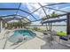 Stunning pool area overlooking a beautiful lake, complete with an umbrella and lounge chairs for relaxation at 13215 Amerigo Ln, Venice, FL 34293
