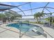Sparkling pool with a sun shelf surrounded by a screened enclosure and scenic views at 13215 Amerigo Ln, Venice, FL 34293