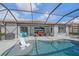 Inviting pool area with outdoor seating and a grill, ideal for entertaining guests and enjoying summer fun at 13215 Amerigo Ln, Venice, FL 34293