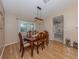 Dining room with wood table and chairs, stylish light fixture, and a view to the kitchen at 1340 Olympia Rd, Venice, FL 34293