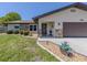 Charming home featuring a stone facade, landscape, and a two-car garage at 1340 Olympia Rd, Venice, FL 34293
