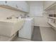 Functional laundry room with a utility sink, washer, dryer, and ample storage shelving at 1340 Olympia Rd, Venice, FL 34293