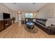 Open-concept living room with wood flooring, large windows, and a leather sectional couch at 1340 Olympia Rd, Venice, FL 34293