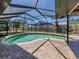 Beautiful screened-in pool with brick pavers and clear blue sky above at 1340 Olympia Rd, Venice, FL 34293