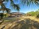View of the back of the house with a large screened-in lanai overlooking the expansive yard at 14352 Pocono Ave, Port Charlotte, FL 33981