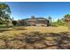 Back of house, featuring large, screened in lanai and expansive backyard surrounded by mature foliage at 14352 Pocono Ave, Port Charlotte, FL 33981