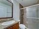 Bathroom featuring granite counters, bowl sink, framed mirror, and tiled shower with glass door at 14352 Pocono Ave, Port Charlotte, FL 33981