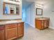 Dual vanity bathroom with granite countertops, wood cabinets, and tile flooring at 14352 Pocono Ave, Port Charlotte, FL 33981